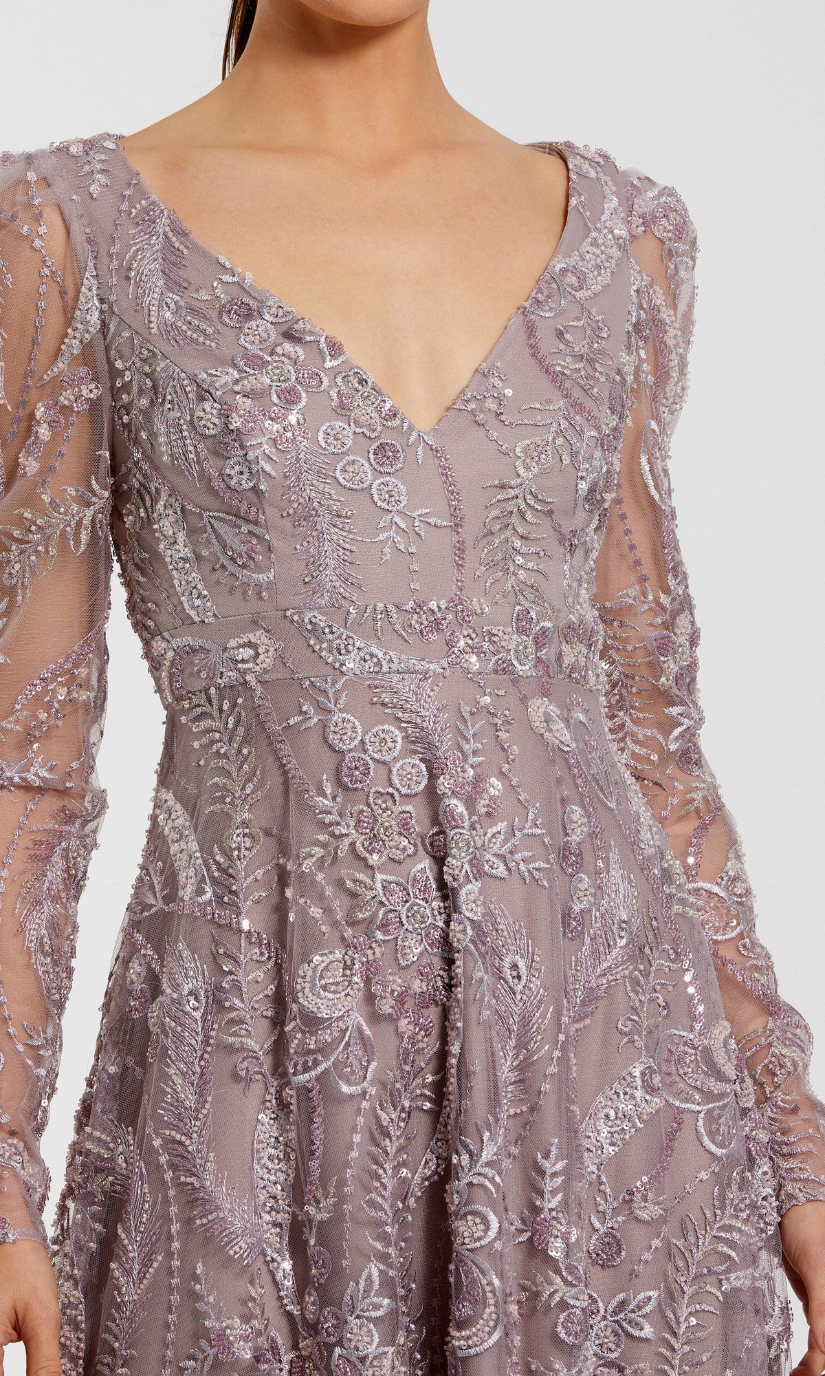 A woman wearing the Mac Duggal 68908 long formal dress in mauve, featuring sheer long sleeves, intricate floral embroidery, and a deep V-neckline.